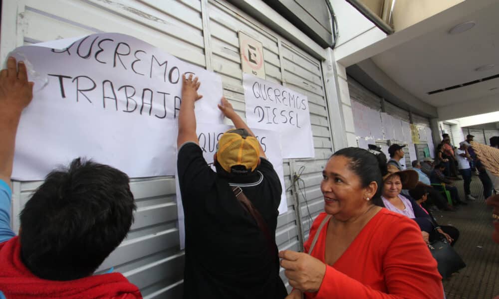 Transportistas pegan carteles durante una protesta en las oficinas de Impuestos Nacionales (SIN), este jueves, en Santa Cruz, (Bolivia). EFE/ Juan Carlos Torrejón