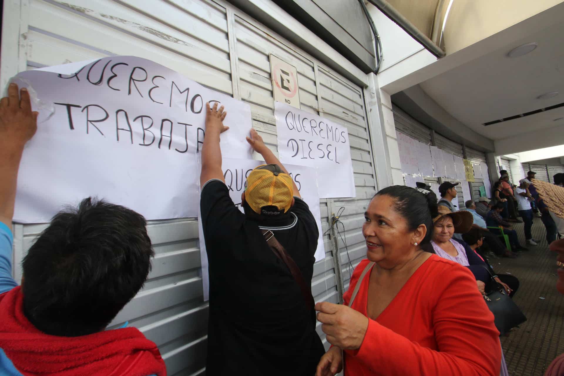 Transportistas pegan carteles durante una protesta en las oficinas de Impuestos Nacionales (SIN), este jueves, en Santa Cruz, (Bolivia). EFE/ Juan Carlos Torrejón