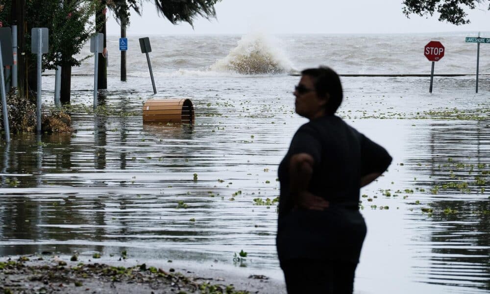 Fotografía de archivo de una mujer frente a una carretera inundada cerca del lago Pontchartrain, en Estados Unidos, mientras se aproxima un huracán EFE/ DAN ANDERSON