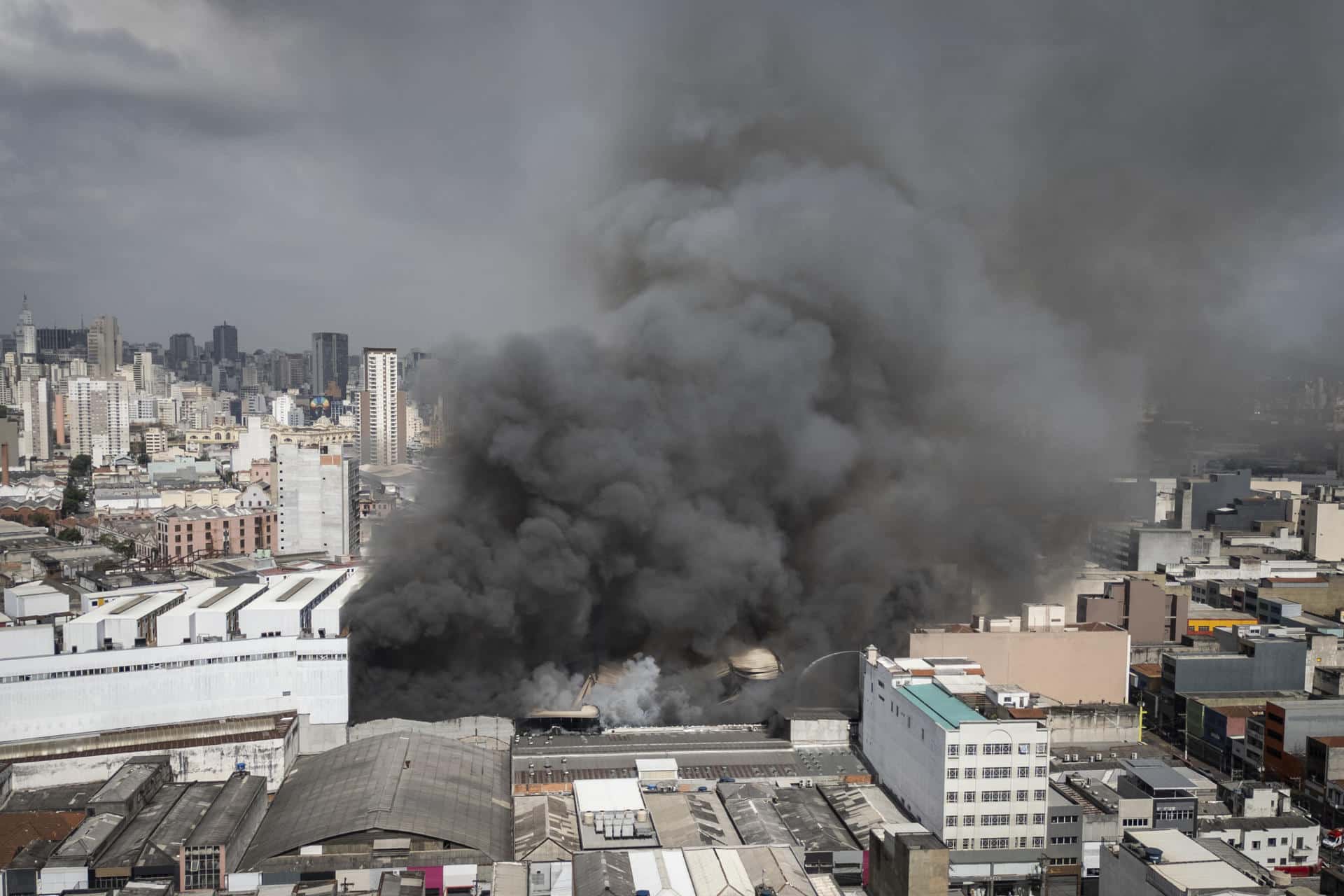 Fotografía aérea de un incendio que afectó el edificio Shopping 25 de Marzo, ubicado en Brás, una de las principales zonas comerciales de la ciudad, este miércoles, en Sao Paulo (Brasil). Más de 60 bomberos trabajan para apagar un incendio en un edificio comercial en el centro de São Paulo que comenzó durante la madrugada de este miércoles y desató una gran humareda en la zona, informó el Cuerpo de Bomberos de la ciudad. EFE/ Isaac Fontana