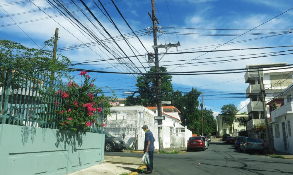 Fotografía del 11 de septiembre de 2024 de un hombre caminando por una calle con tendidos eléctricos en el barrio de Santurce, en San Juan (Puerto Rico). EFE/Esther Alaejos