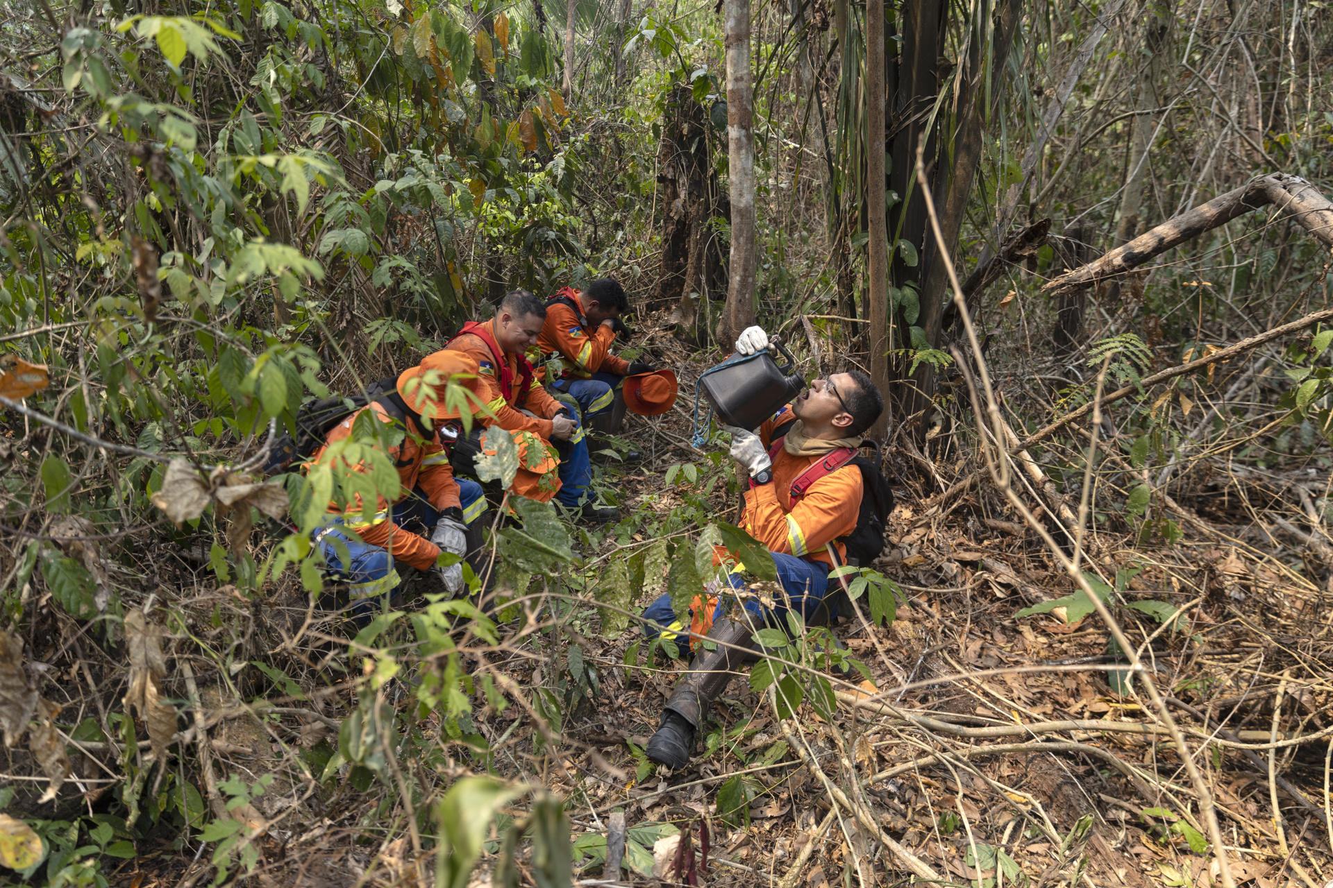 Fotografía de archivo de bomberos mientras se hidratan durante un recorrido para apagar incendios en varias áreas quemadas del Parque Estatal Guajará Mirim en la ciudad de Nova Mamoré (Brasil). EFE/ Isaac Fontana