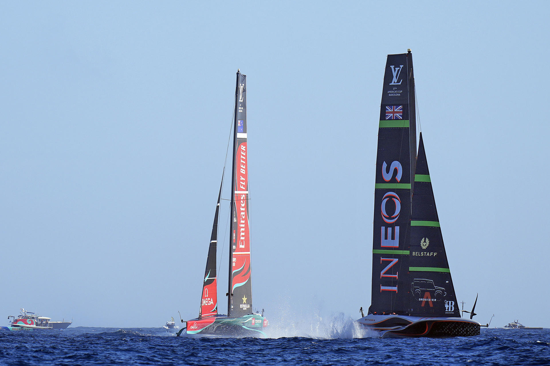 El velero defensor del título de la Copa del América, el Emirates Team New Zealand (i), navega junto al equipo desafiante, el INEOS Britannia (d), durante la cuarta jornada del enfrentamiento final en las aguas de Barcelona. EFE/Siu Wu