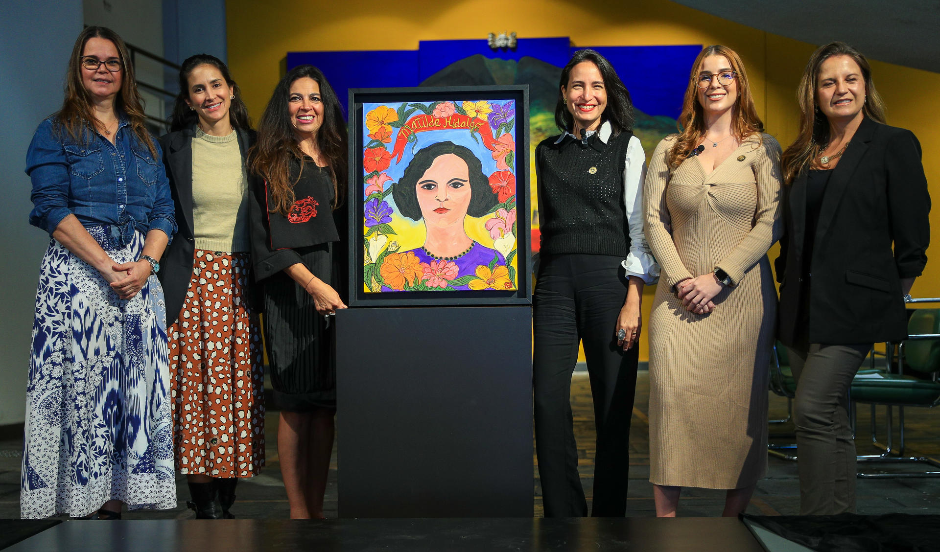 Ana Fernández (c-i), posa junto a las ministras de Cultura y Patrimonio, Romina Muñoz (c-d); de la Mujer y Derechos Humanos, Arianna Tanca (2-d), e Ileana Procel (i), nieta de Hidalgo, mientras muestra el retrato de Matilde Hidalgo, primera mujer en ejercer el voto en América Latina, este 16 de octubre de 2024, en Quito (Ecuador). EFE/ José Jácome