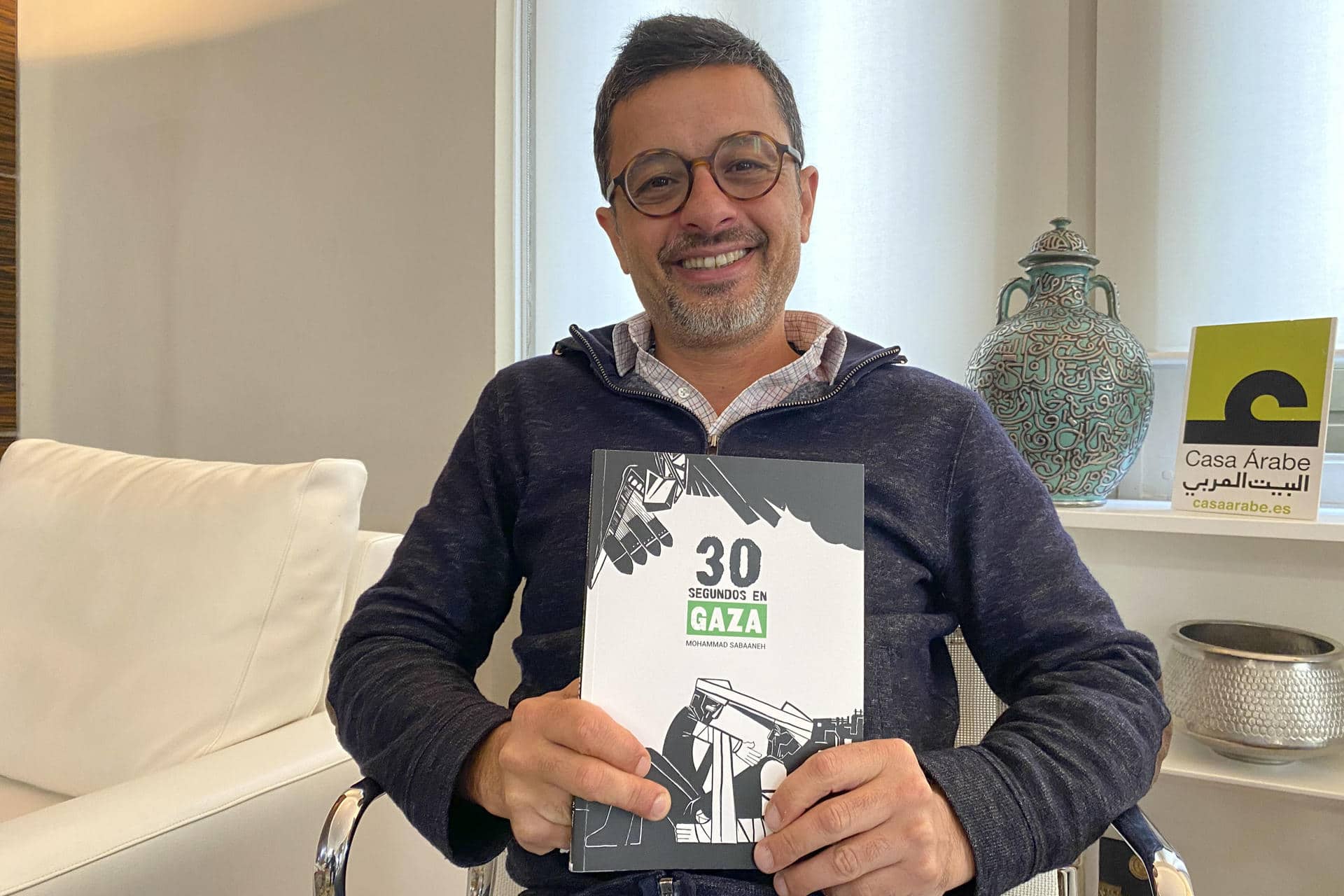 El ilustrador palestino Mohammad Sabaaneh posa con su libro '30 segundos en Gaza" durante la presentación en la Casa Árabe de Madrid. Sabaaneh cree que la gente no puede ver completos los vídeos cortos que circulan en redes sociales desde Palestina, y por eso publica "30 segundos en Gaza", un libro de ilustraciones que reflejan la "atrocidad" de la guerra. "Son solo 30 segundos de toda una vida de un ser humano que está sufriendo en Gaza. Y tras estos 30 segundos, su vida habrá cambiado", dijo en una entrevista con EFE en Madrid, y explicó que su libro quiere ser un testimonio duradero para mantener vivas las imágenes que redes sociales y el Gobierno de Israel tratan de censurar. EFE/ Patricia Cotelo Bertaiola