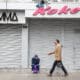 Una persona camina junto a locales comerciales cerrados, durante un paro convocado por gremios de transporte y comercio, este miércoles, en la ciudad de Lima (Perú). EFE/ Paolo Aguilar