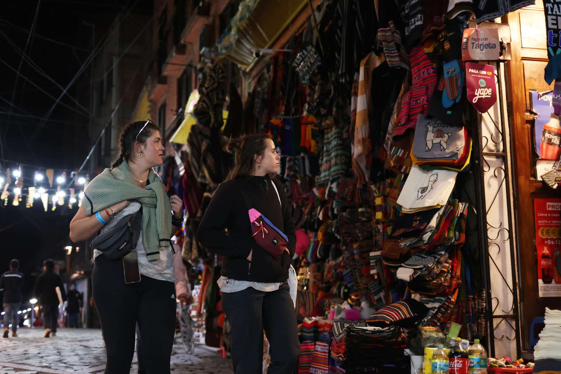 Turistas pasean en el sector turístico conocido como el Callejón de las Brujas, en el centro de la ciudad de La Paz (Bolivia). La inestabilidad social, que es casi una constante en Bolivia, se ha ensañado con sectores de la economía naranja como el turismo y la gastronomía. EFE/ Luis Gandarillas