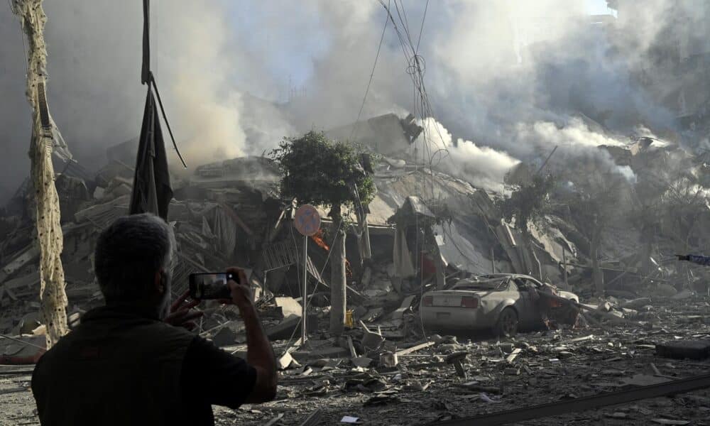 Un hombre fotografía un edificio humeante después de un ataque aéreo israelí sobre el barrio de Dahieh, uno de los bastiones de Hizbulá, en Beirut (El Líbano) estes jueves. EFE/ Wael Hamzeh