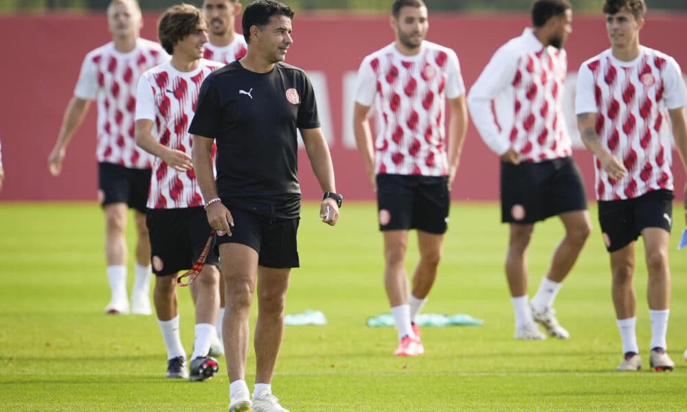 El entrenador del Griona FC, Michel Sánchez (i), y varios de sus jugadores durante el entrenamiento que el equipo gironés ha realizado en la Girona Football Academy para preparar el partido de Liga de Campeones que disputarán ante el Feyenoord. EFE/David Borrat.