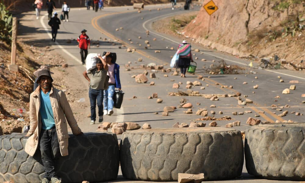 Personas caminan con sus equipajes durante la segunda jornada de bloqueos por seguidores del expresidente Evo Morales (2006-2019) este martes, en Cochabamba (Bolivia). EFE/Jorge Ábrego