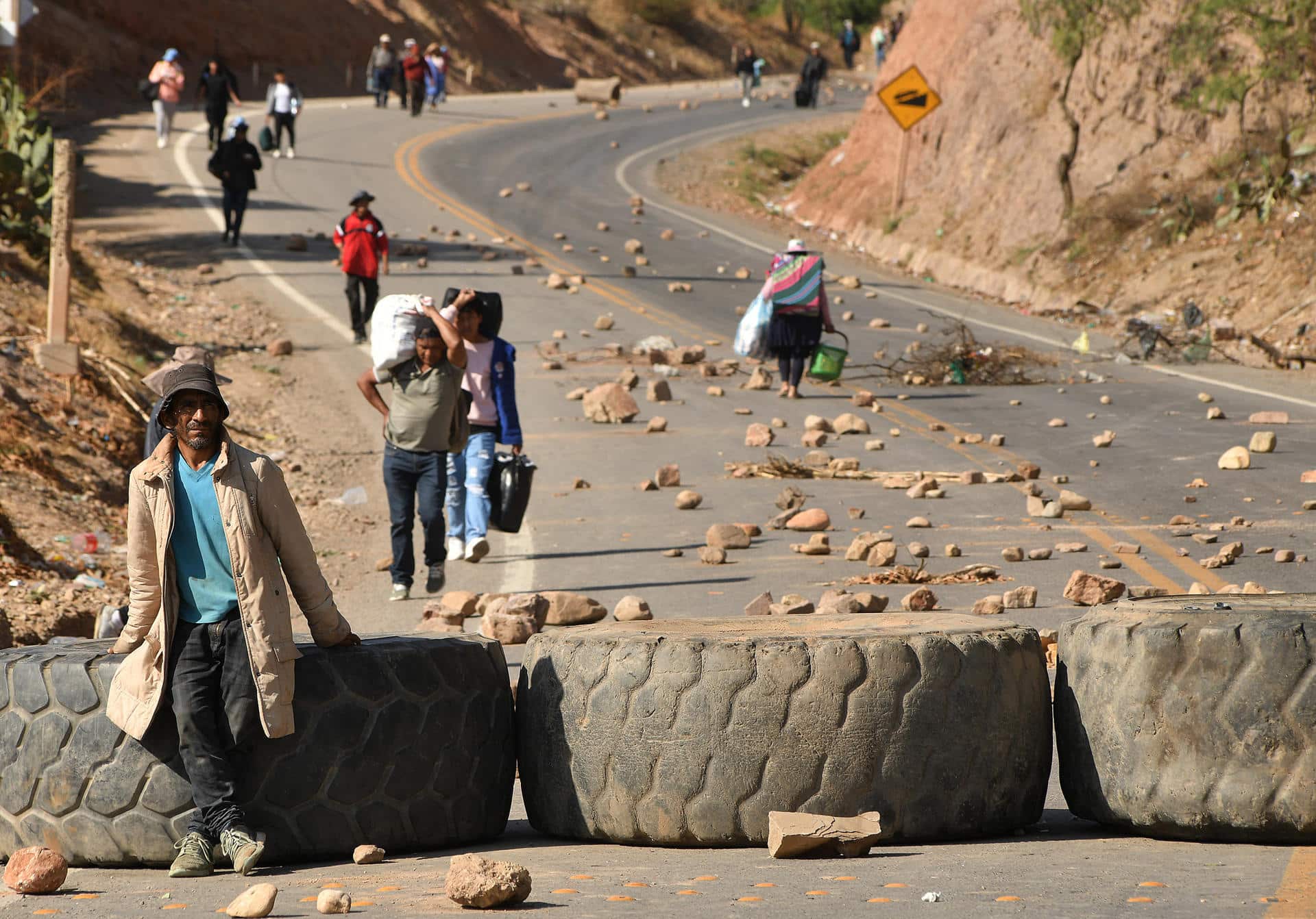 Personas caminan con sus equipajes durante la segunda jornada de bloqueos por seguidores del expresidente Evo Morales (2006-2019) este martes, en Cochabamba (Bolivia). EFE/Jorge Ábrego