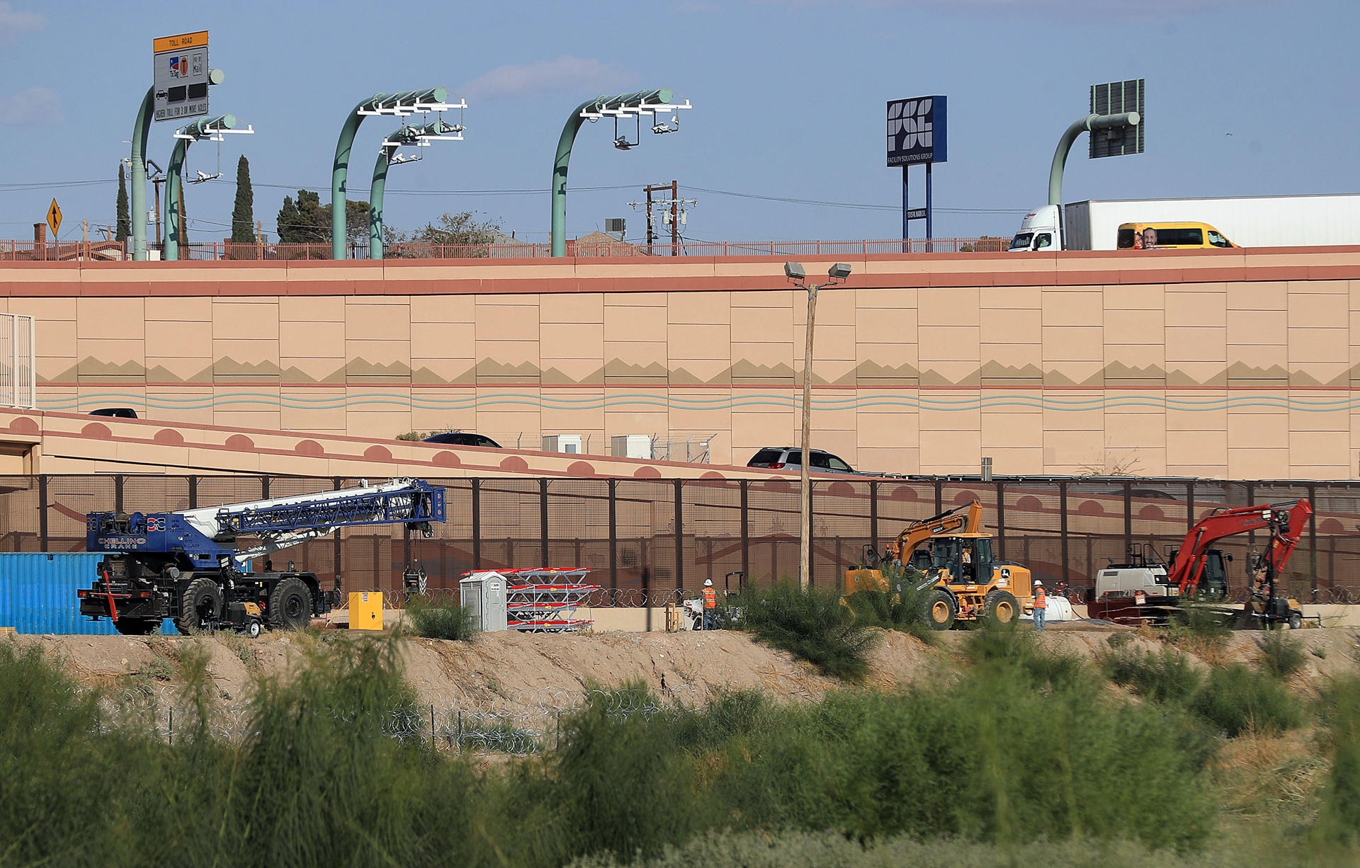 Trabajadores con maquinaria pesada laboran en la colocación de barricadas de alambre de púas, el 11 de octubre de 2024 en el muro fronterizo de Ciudad Juárez en el estado de Chihuahua (México). EFE/Luis Torres