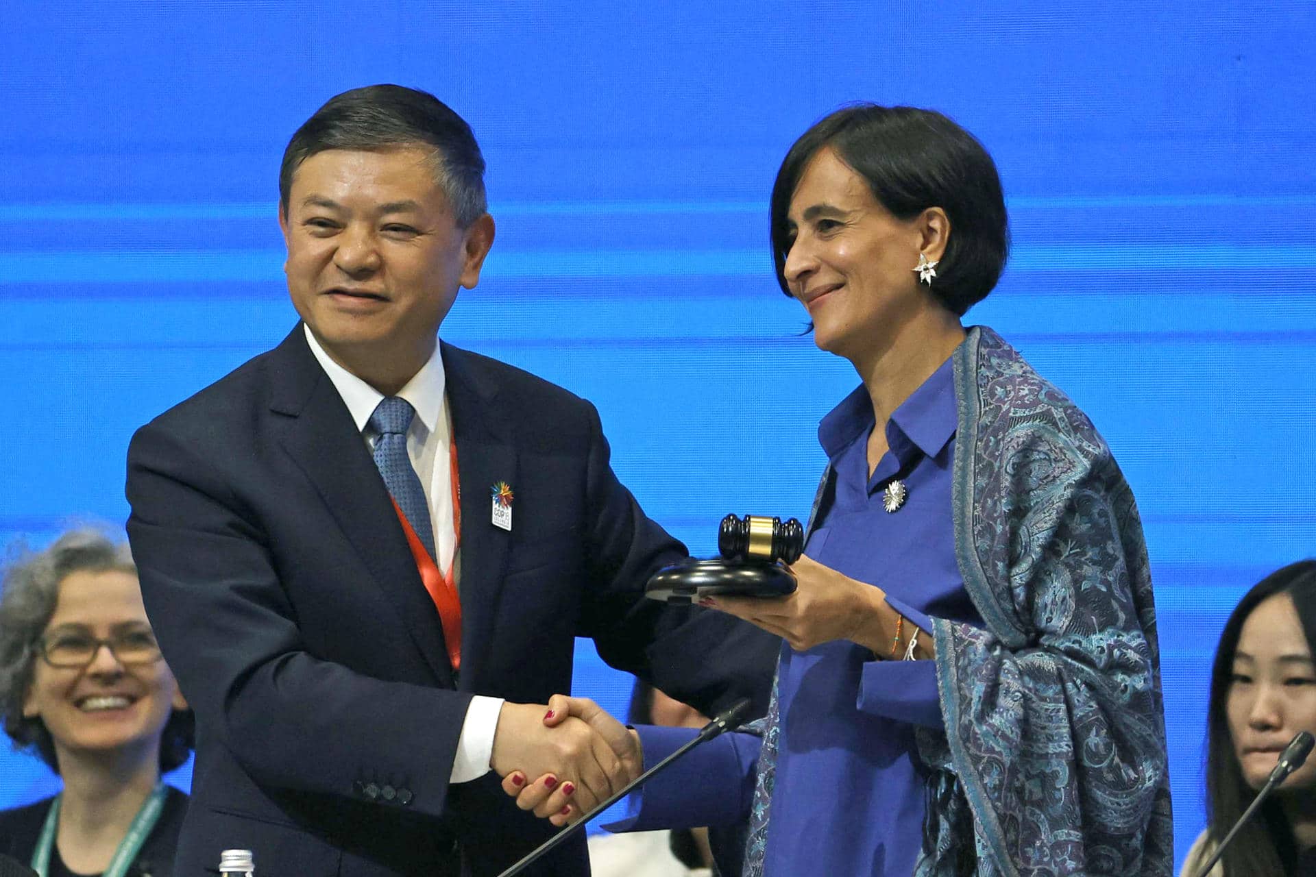 El Ministro de Ecología y medio ambiente de China, Huang Runqiu (i) entrega el mazo de la presidencia de la Cumbre de Naciones Unidas de Biodiversidad, COP16, a la ministra de Ambiente y Desarrollo Sostenible de Colombia, Susana Muhamad, durante el inicio de la primera plenaria, este lunes, en Cali (Colombia). EFE/ Mauricio Dueñas Castañeda