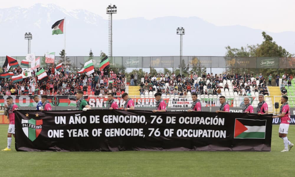 Fotografía cedida por Comunicaciones Club Deportivo Palestino de jugadores de ese equipo sosteniendo una pancarta antes de empezar un partido este domingo, en Santiago de Chile (Chile).. EFE/ Comunicaciones Club Deportivo Palestino /