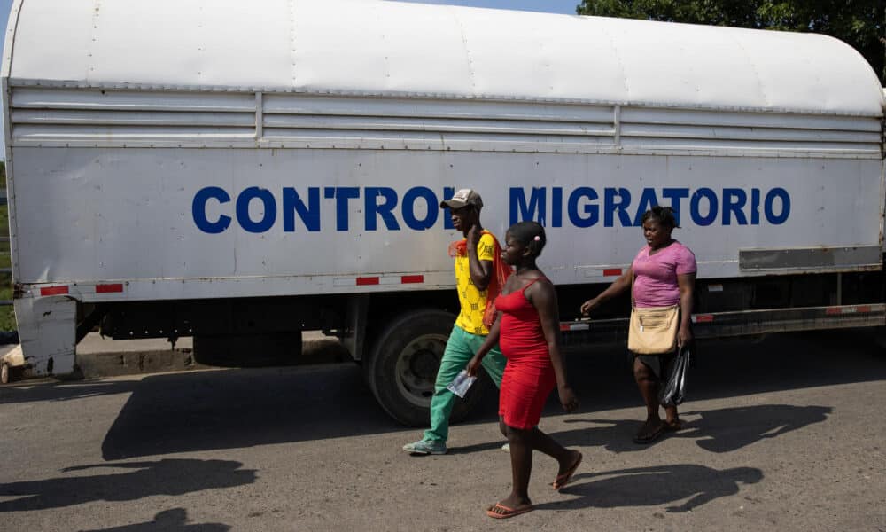 Fotografía de haitinianos junto a un camión de la Dirección General de Migración dominicana. EFE/ Orlando Barría