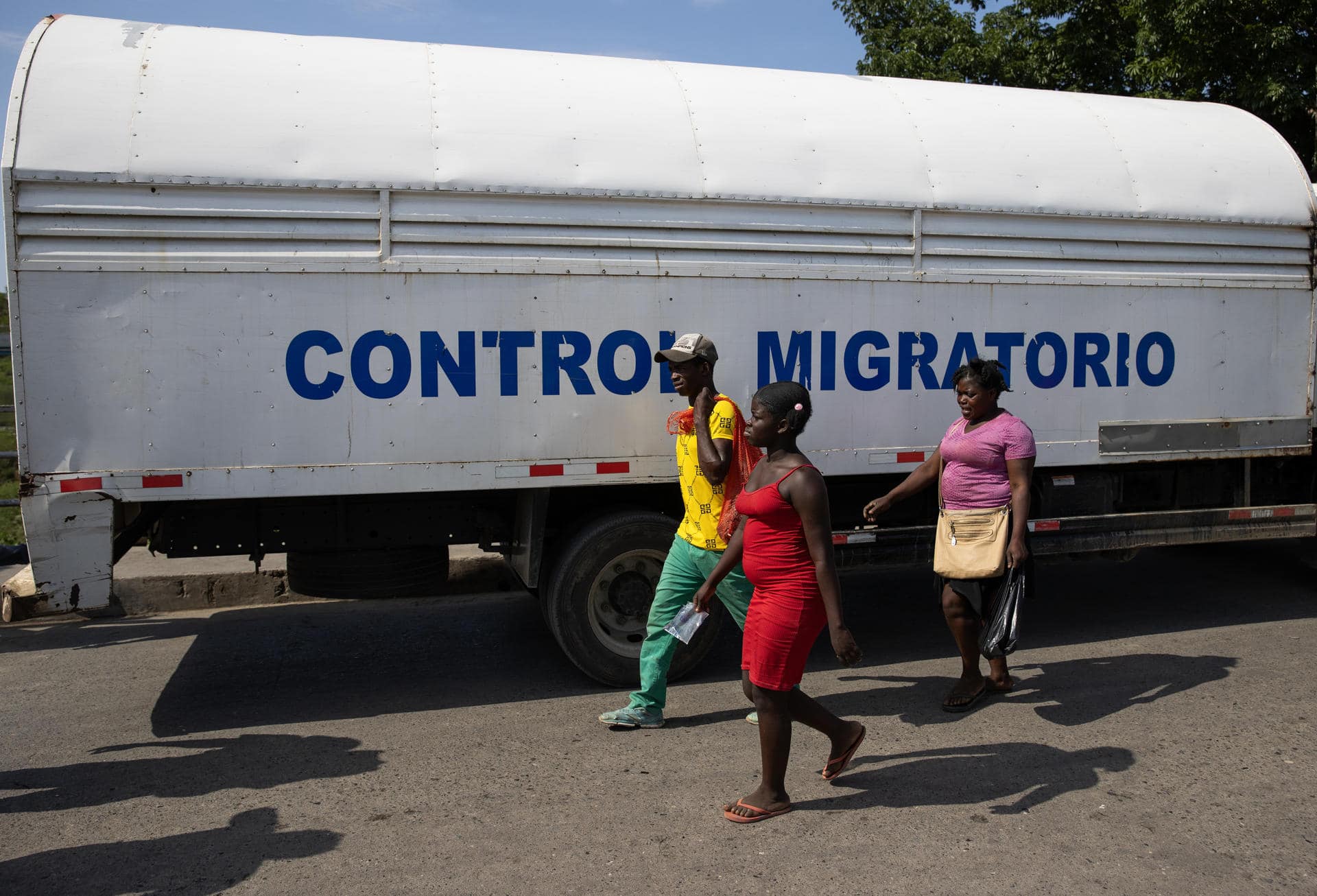 Fotografía de haitinianos junto a un camión de la Dirección General de Migración dominicana. EFE/ Orlando Barría