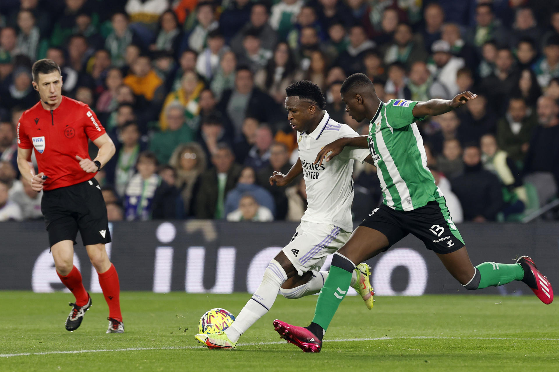 Imagen de archivo del delantero del Real Madrid Vinicius Junior (c) jugando un balón ante Luiz Henrique (d), del Betis, durante el partido de LaLiga que Real Betis y Real Madrid disputaron en el estadio Benito Villamarín, en Sevilla. EFE/Julio Muñoz