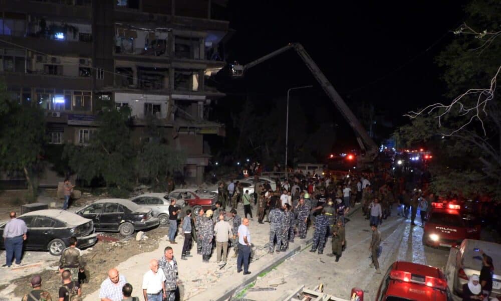 Soldados y ciudadanos sirios inspeccionan los daños causados ​​por la caída de misiles sobre un edificio en el barrio de Al-Mazzeh en Damasco, Siria, el 8 de octubre de 2024. Al menos siete personas murieron y otras 11 resultaron heridas después de que tres misiles israelíes cayeran sobre el edificio. EFE/EPA/STRINGER