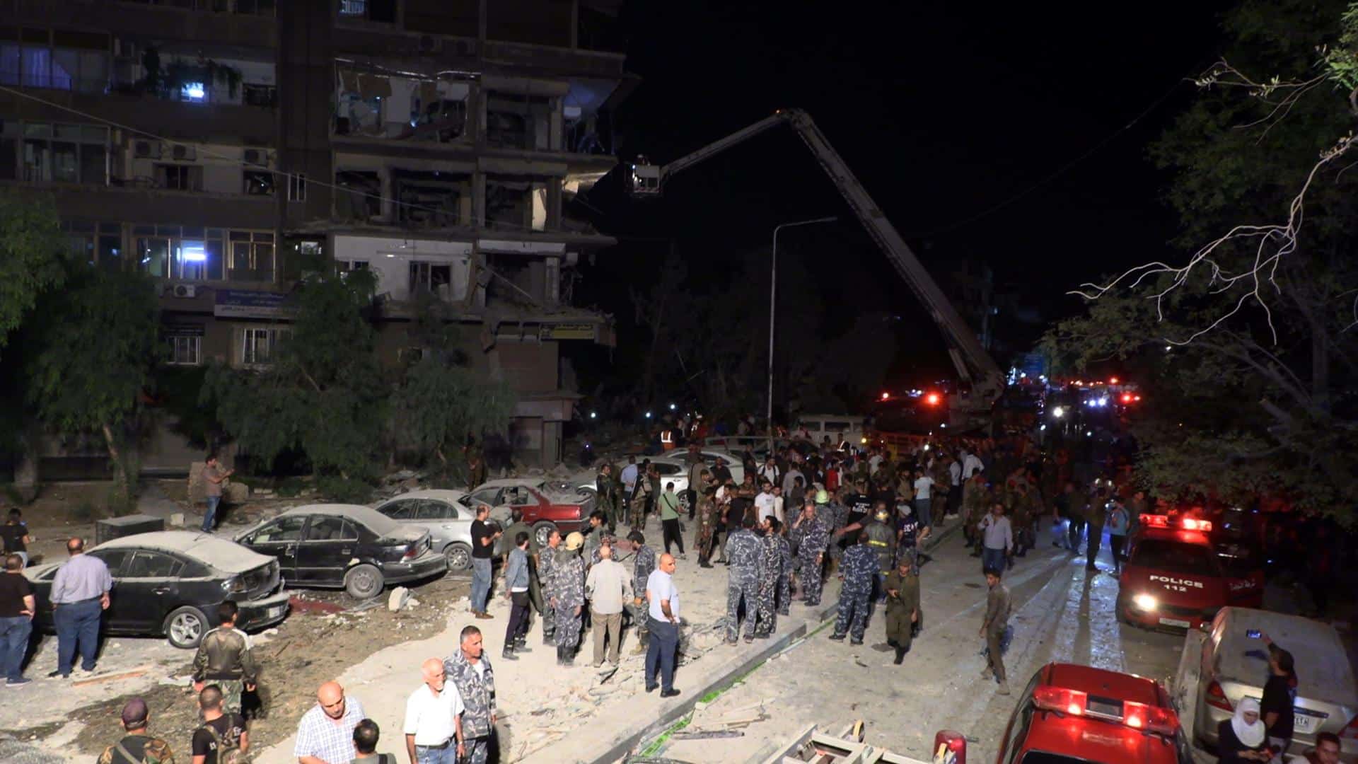 Soldados y ciudadanos sirios inspeccionan los daños causados ​​por la caída de misiles sobre un edificio en el barrio de Al-Mazzeh en Damasco, Siria, el 8 de octubre de 2024. Al menos siete personas murieron y otras 11 resultaron heridas después de que tres misiles israelíes cayeran sobre el edificio. EFE/EPA/STRINGER