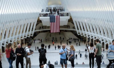 Personas conversan frente a una bandera estadounidenses colgada en el centro de la estación del "Oculos" en el World Trade Center en Nueva York (EE.UU.). Archivo. EFE/Kena Betancur