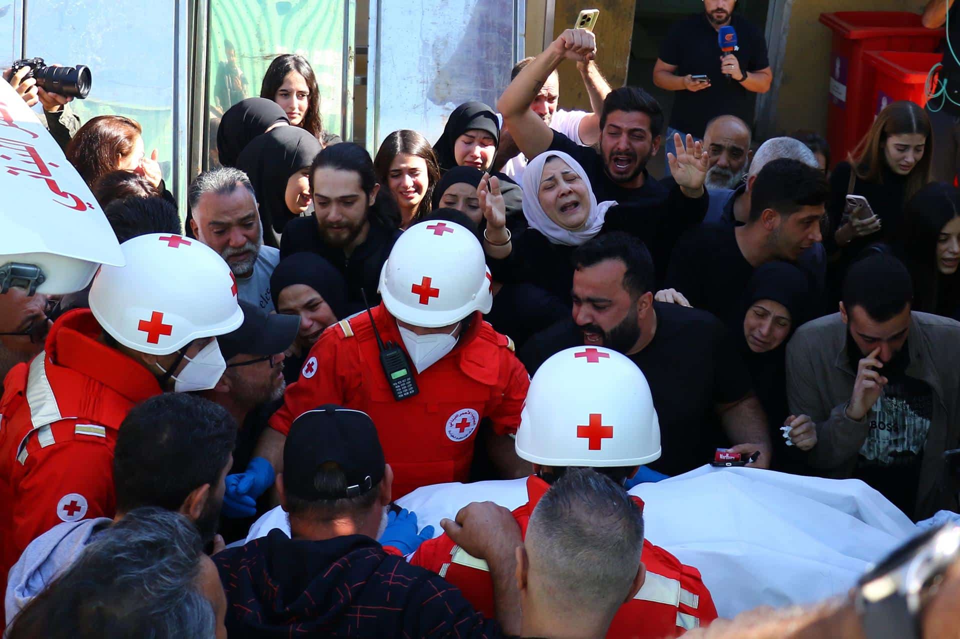 Miembros de la Cruz Roja llevan los cuerpos de tres periodistas asesinados en un ataque israelí en el sur del Líbano en un hospital de Beirut, Líbano, el 25 de octubre de 2024. Según el Ministerio de Salud libanés, al menos tres periodistas murieron y otros tres resultaron heridos el 25 de octubre en un ataque israelí en Hasbaya, en el sur del Líbano. El canal de televisión Al Mayadeen informó sobre la muerte de su camarógrafo y su ingeniero de transmisión, mientras que Al-Manar TV dijo que su camarógrafo murió en el ataque. Según el Ministerio de Salud libanés, más de 2.500 personas han muerto y más de 12.000 han resultado heridas en el Líbano desde el inicio de las recientes escaladas de hostilidades. (Líbano) EFE/EPA/STR