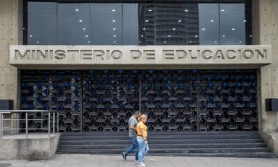 Fotografía de archivo del 21 de abril de 2023 de dos personas frente a las instalaciones del Ministerio de Educación, en Caracas (Venezuela).EFE/ Miguel Gutiérrez