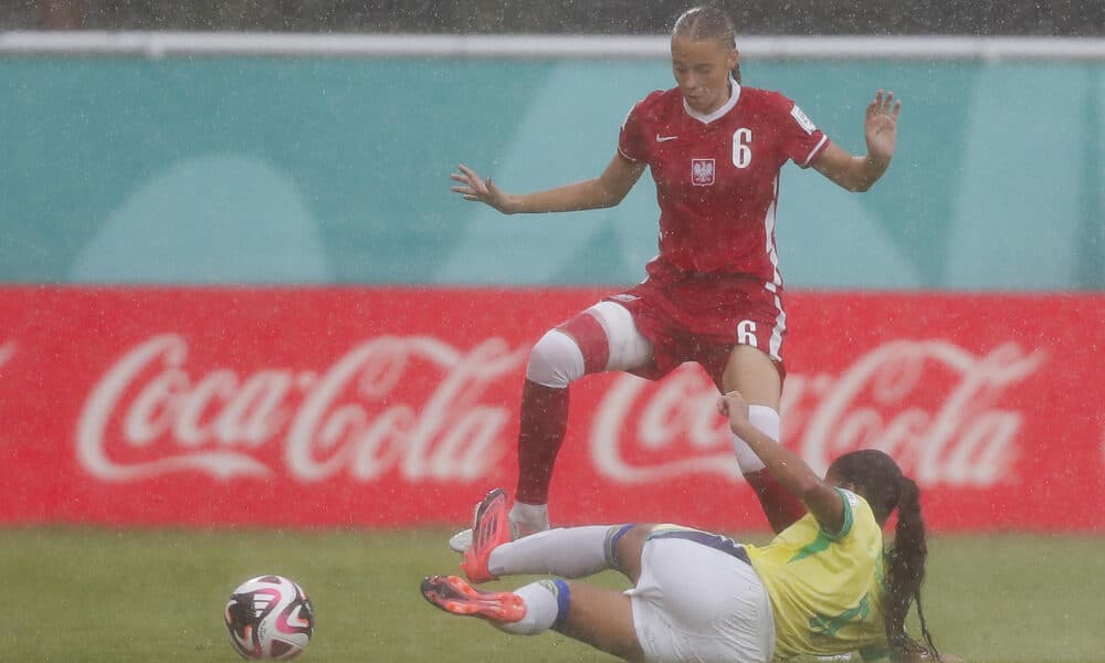 Iga Witkowska (i), de Polonia, disputa un balón con la brasileña Giovanna Waksman en partido del grupo D que se jugó bajo un torrencial aguacero y que dejó eliminada a la Canarinha en Santiago de los Caballeros. EFE/ Diana Sánchez