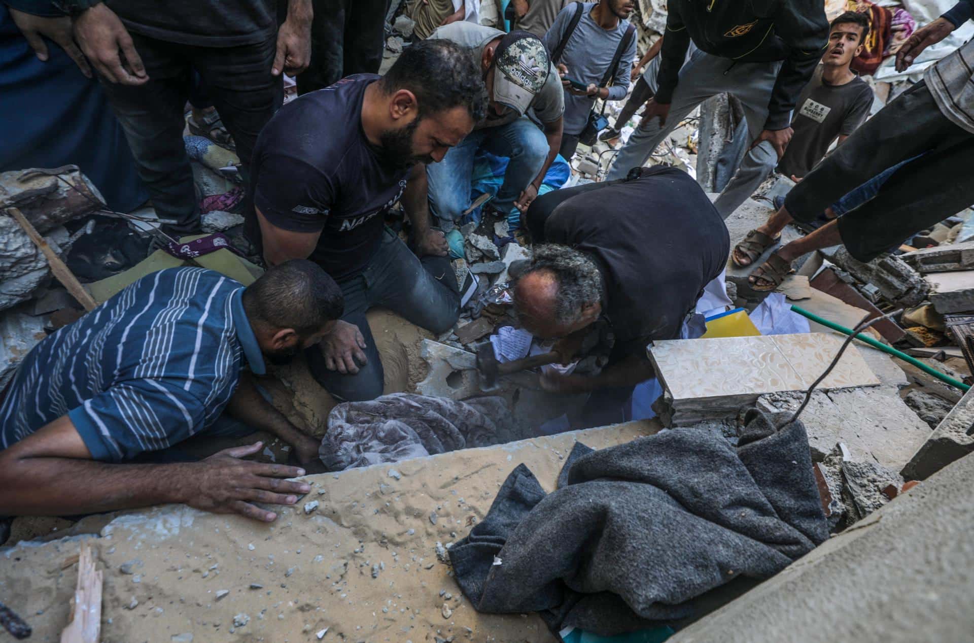 Palestinos recuperan a las víctimas de los escombros de una casa destruida tras un ataque aéreo israelí en el campo de refugiados de Al Maghazi, en la Franja de Gaza, el 19 de octubre de 2024. EFE/EPA/MOHAMMED SABER