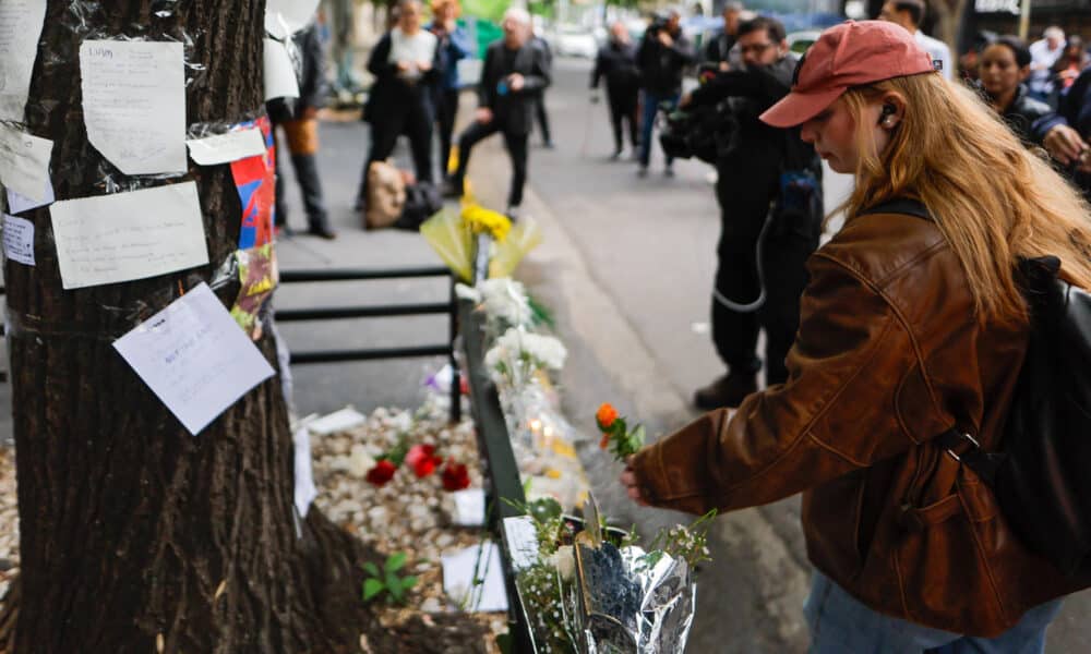 Una mujer coloca flores frente al hotel donde falleció el exintegrante de la banda One Direction, Liam Payne, este jueves, en la ciudad de Buenos Aires (Argentina). EFE/ Juan Ignacio Roncoroni