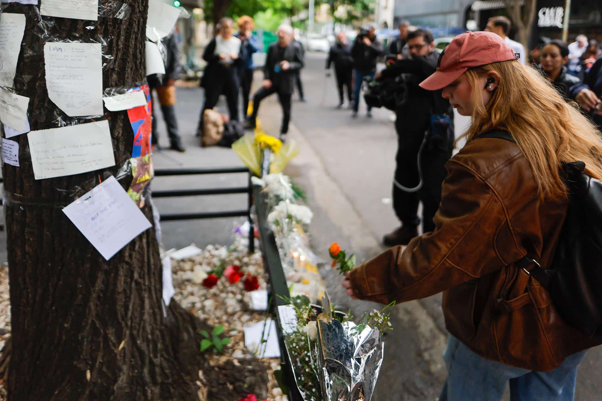 Una mujer coloca flores frente al hotel donde falleció el exintegrante de la banda One Direction, Liam Payne, este jueves, en la ciudad de Buenos Aires (Argentina). EFE/ Juan Ignacio Roncoroni