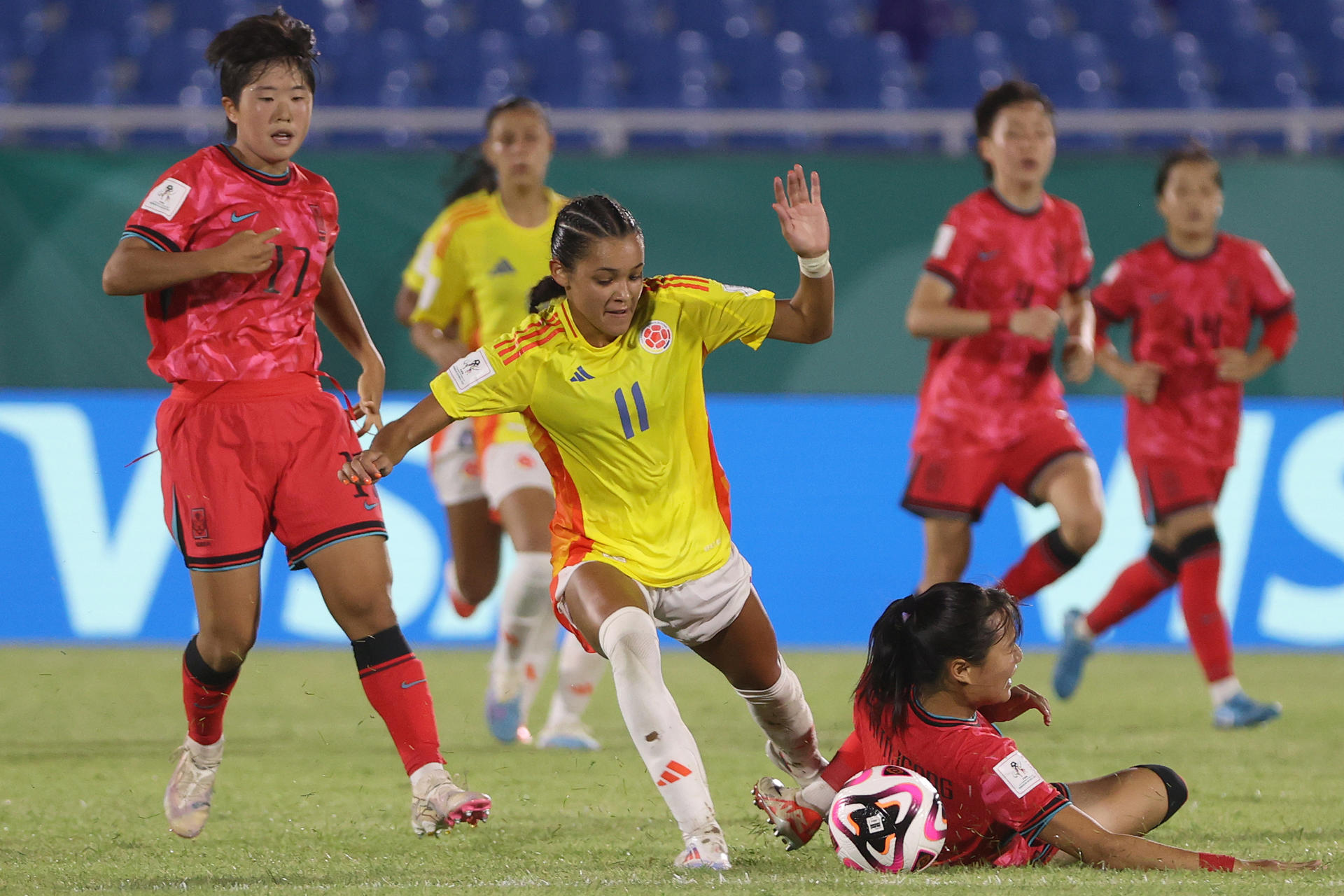 Jung Yujeong (abajo), de Corea del Sur, disputa el balón con Ella Martinez, de Colombia, en el estadio Olímpico Félix Sánchez de Santo Domingo. EFE/Orlando Barría