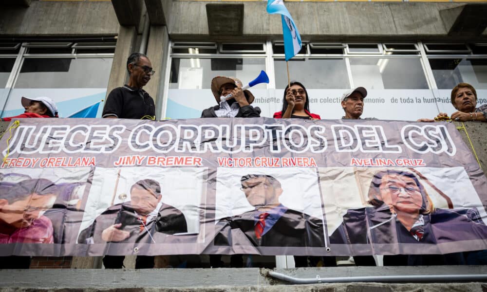 Fotografía de archivo de personas que exhiben un cartel con jueces señalados de corrupción que aspiran a formar parte de las altas cortes de Guatemala, durante una protesta el 20 de septiembre de 2024, en la Ciudad de Guatemala (Guatemala). EFE/ David Toro