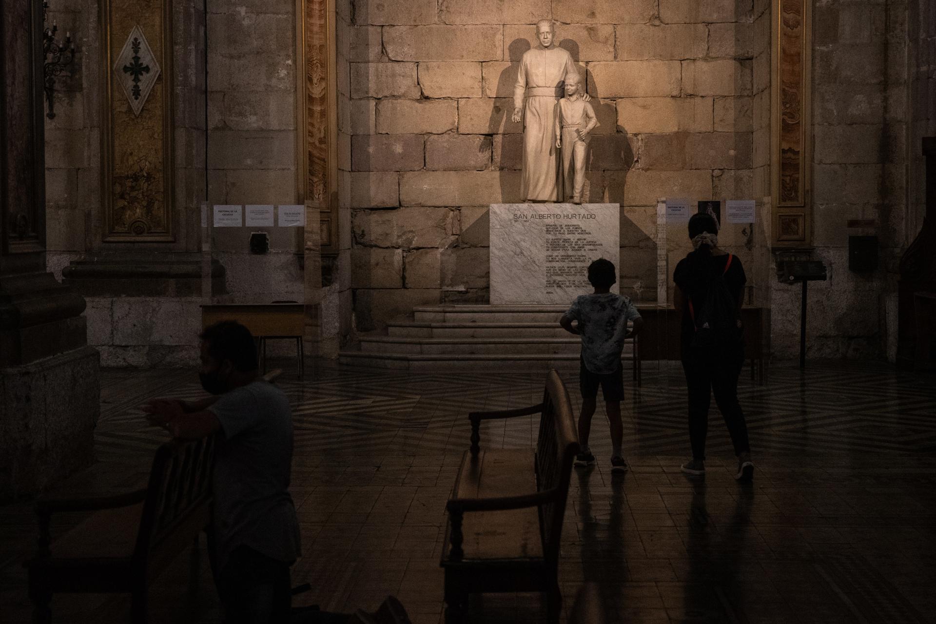 Fotografía de archivo en donde una madre y su hijo observan una estatua junto a la Catedral Metropolitana de Santiago (Chile), uno de los escenarios donde se investiga la comisión de delitos de abuso sexual por parte de integrantes de la Iglesia. EFE/ Alberto Valdés