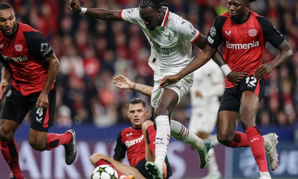 Los defensas del Leverkusen Jonathan Tah (I) y Edmond Tapsoba tratan de frenar al delantero del Milan Tammy Abraham durante el partido de la segunda jornada de la UEFA Champions League que han jugado Bayer Leverkusen y AC Milan en Leverkusen, Alemania. EFE/EPA/CHRISTOPHER NEUNDORF