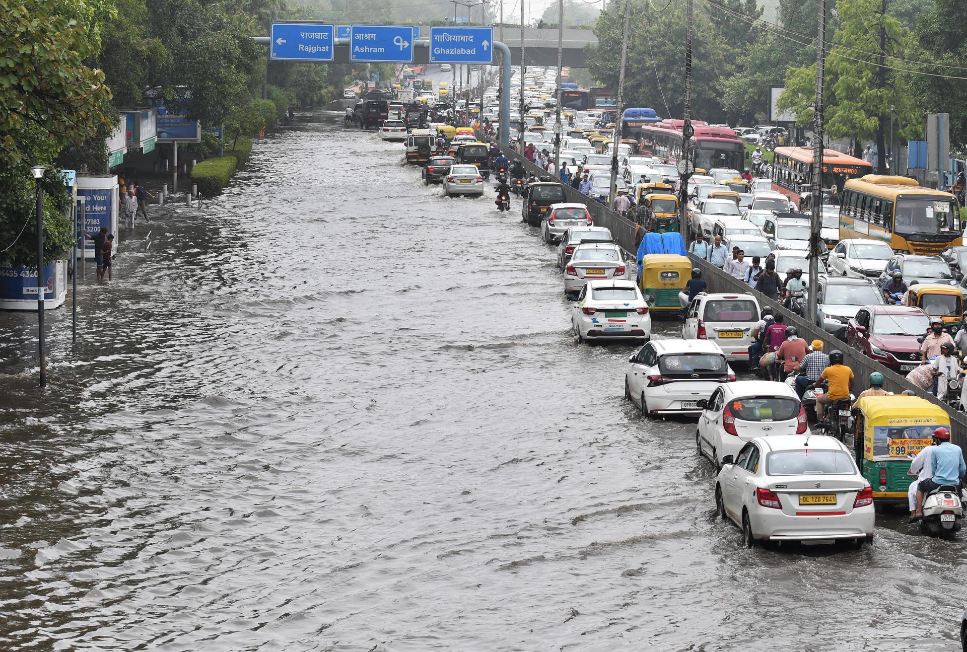 Un atasco en medio de una vía inundada a causa de fuertes precipitaciones causadas por los monzones en Nueva Delhi. Archivo EFE/MANISH JAIN