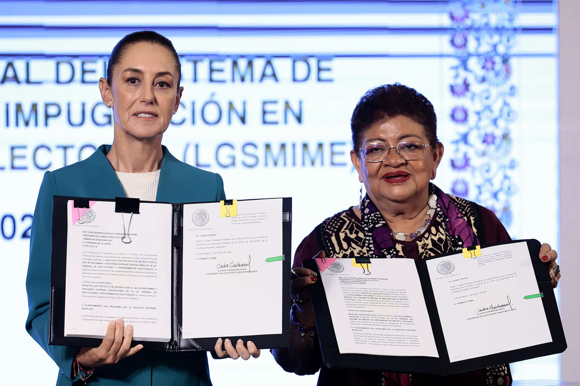 La presidenta de México, Claudia Sheinbaum (i), y la consejera jurídica de la Presidencia, Ernestina Godoy, muestran dos iniciativas este lunes, durante una conferencia de prensa en Palacio Nacional de la Ciudad de México (México). EFE/ José Méndez