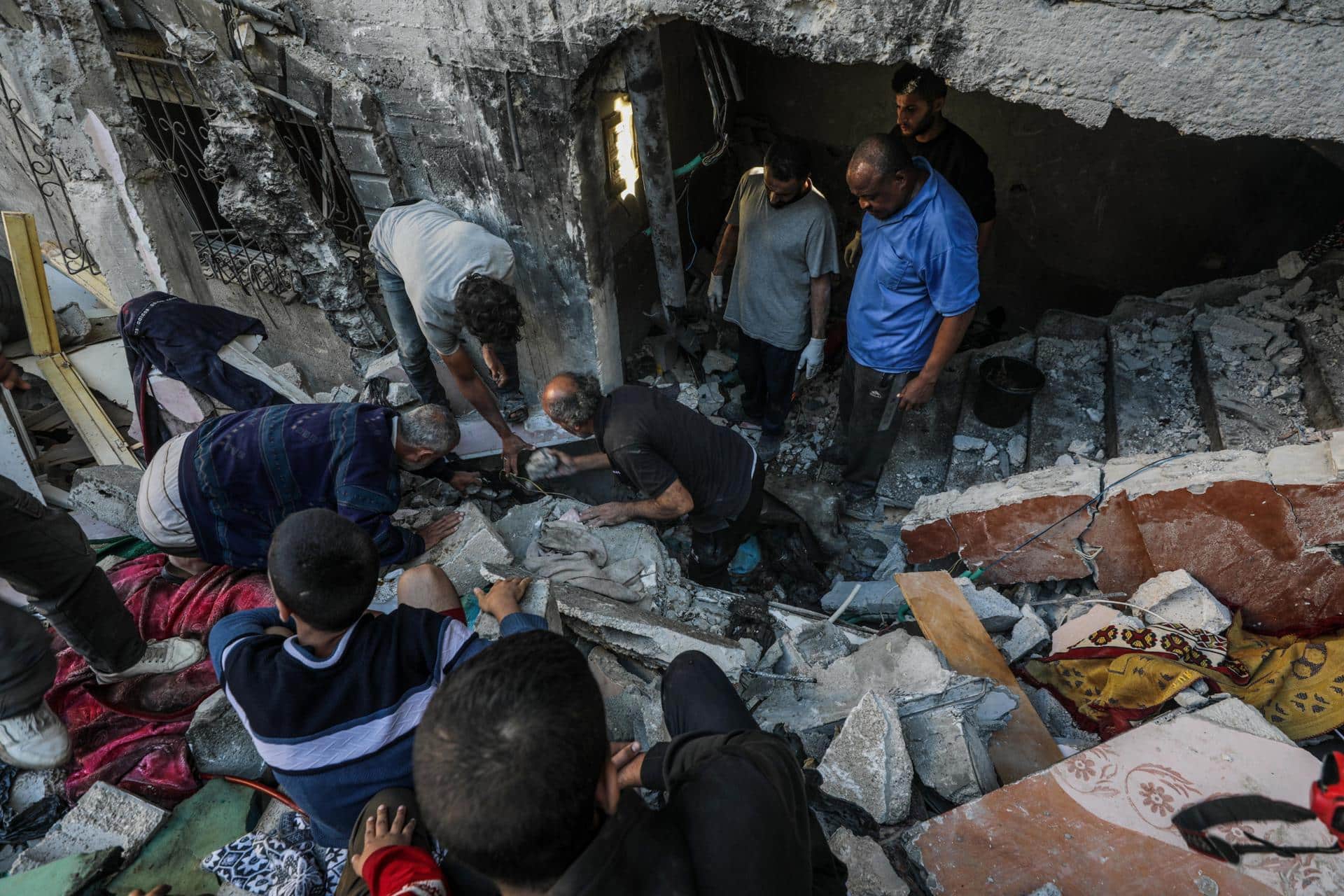 Palestinos buscan cadáveres y supervivientes entre los escombros de una casa destruida tras un ataque aéreo israelí en el campo de refugiados de Al Maghazi, en la Franja de Gaza, el 19 de octubre de 2024. EFE/EPA/MOHAMMED SABER