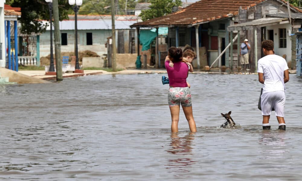 Fotografía de archivo del 29 de octubre de 2024 en donde personas caminan por una calle afectada por las inundaciones, en Batabanó (Cuba). EFE/ Ernesto Mastrascusa