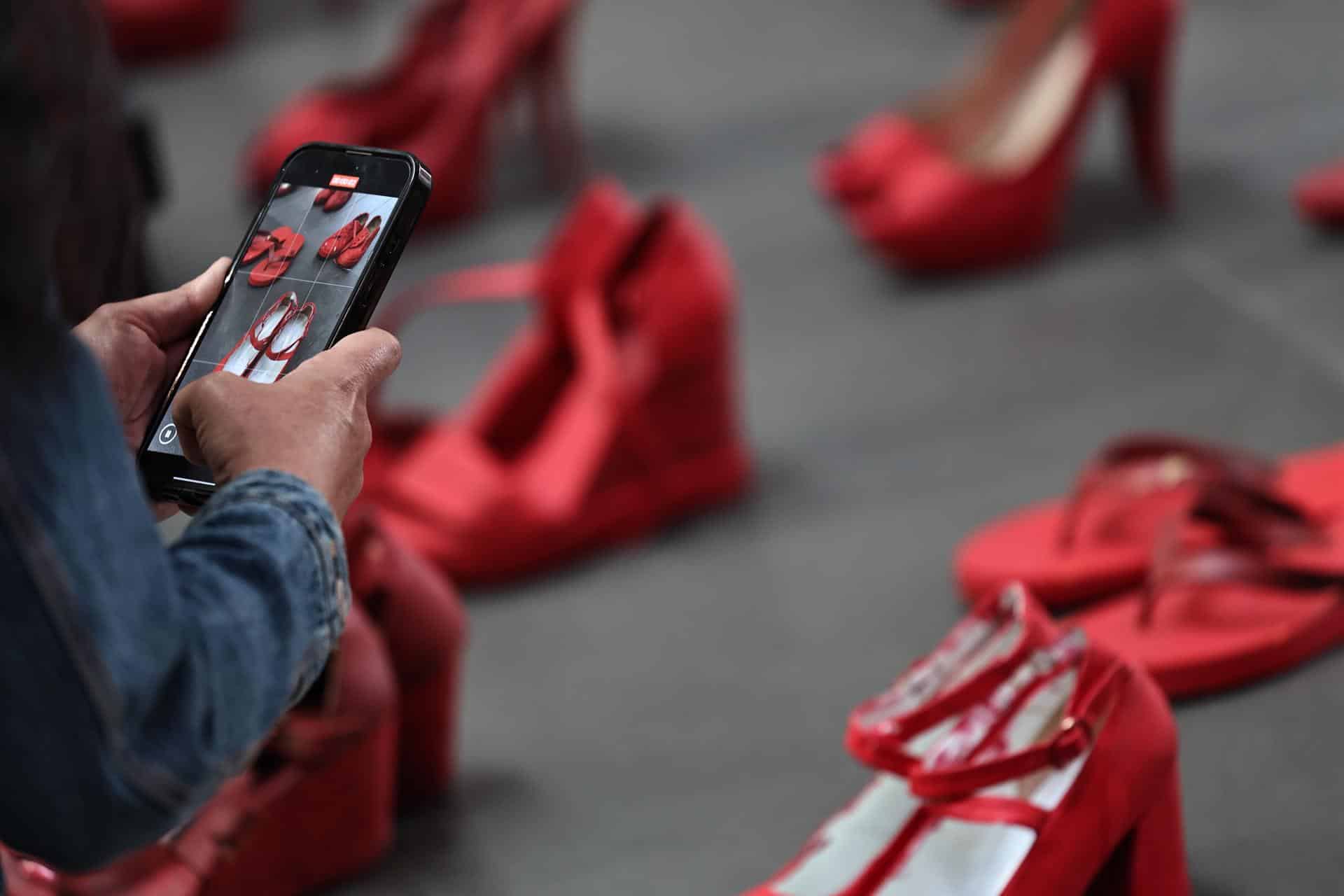 Una persona toma fotos en la exposición 'Zapatos Rojos' de la artista mexicana Elina Chauvet este jueves, en Ciudad de México (México). EFE/Sáshenka Gutiérrez