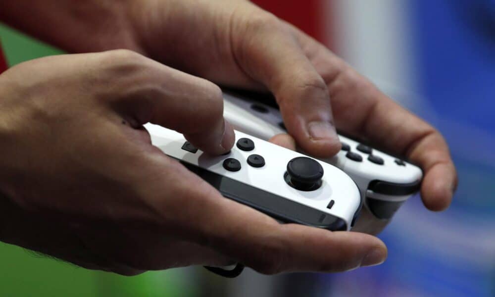 Una persona sujeta con las manos unos controladores Nintendo Switch. EFE/EPA/RUNGROJ YONGRIT