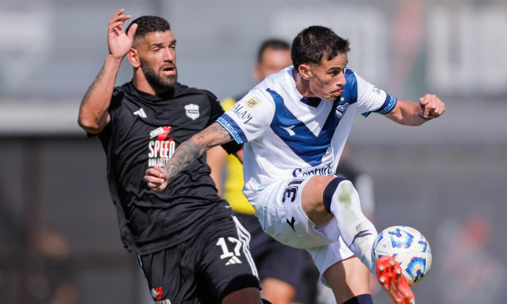 Gustavo Fernández (i), del Deportivo de Riestra, disputa el balón con Valentín Gómez, de Vélez, en juego de la Primera División de Argentina en el estadio Guillermo Laza en Buenos Aires. EFE/ Juan Ignacio Roncoroni