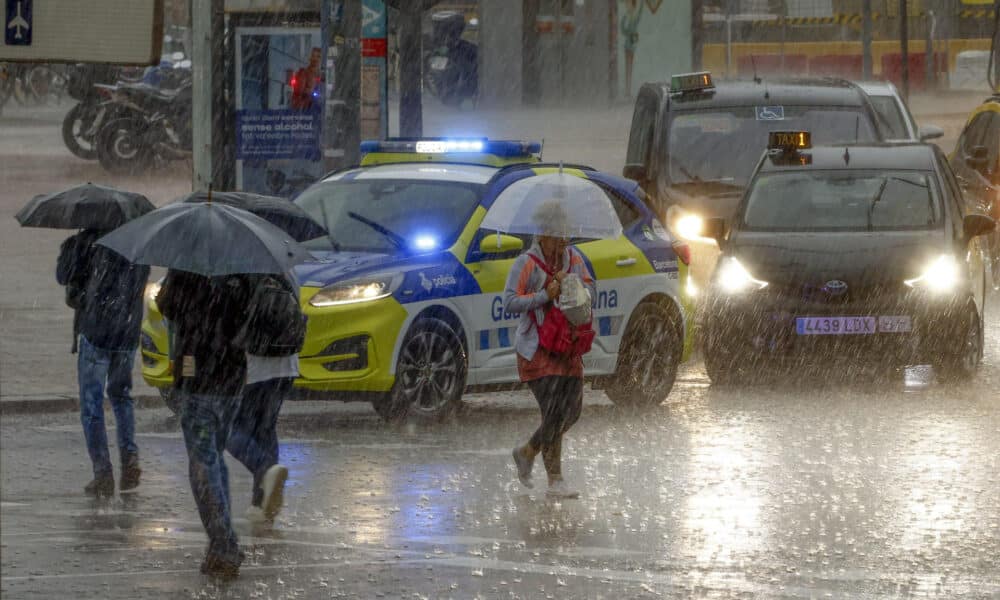 Varias personas se protegen de la lluvia en la Plaza de Espanya de Barcelona este lunes cuando las comarcas de del Garraf y del Barcelonès, en Barcelona, están en aviso rojo de la Agencia Estatal de Meteorología (Aemet), y la Generalitat ha enviado una alerta a los teléfonos móviles por la llegada de lluvias continuadas y torrenciales. EFE/Quique García