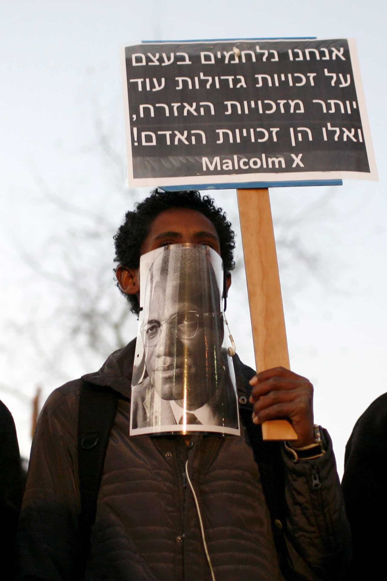 Fotografía de archivo de un hombre sosteniendo una imagen de Malcolm X, durante una manifestación. EFE/ Abir Sultan ARCHIVO