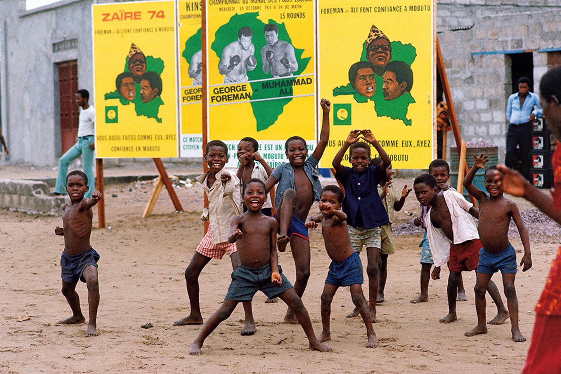 Niños en Kinsasa, el antiguo Zaire, actual capital de la República Democrática del Congo, delante de unos carteles de la pelea entre Muhammad Ali y George Foreman de 1974. EFE/Cedida por Taschen