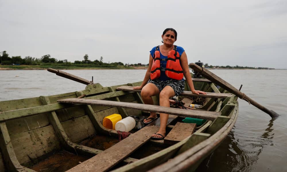 Fotografía de Mónica Bogado, una de las once mujeres pescadoras integrantes de la Asociación San Vicente, posando en el río Paraguay, en Asunción. EFE/ Juan Pablo Pino