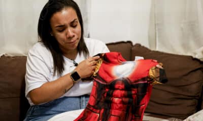 Fotografía del pasado martes que muestra a Beatriz da Silva acariciando un disfraz de superhombre que su hijo Ryan vistió recientemente en la casa en Vila Progresso, un barrio humilde situado sobre una ladera en la ciudad portuaria de Santos (Brasil). EFE/Sebastiao Moreira