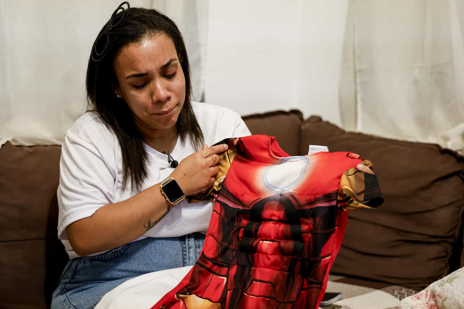 Fotografía del pasado martes que muestra a Beatriz da Silva acariciando un disfraz de superhombre que su hijo Ryan vistió recientemente en la casa en Vila Progresso, un barrio humilde situado sobre una ladera en la ciudad portuaria de Santos (Brasil). EFE/Sebastiao Moreira