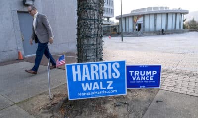 Un hombre camina frente a unos carteles de los candidatos presidenciales, los demócratas Harris y Walz y los republicanos Trump y Vance, en un centro de votación. EFE/ Ángel Colmenares