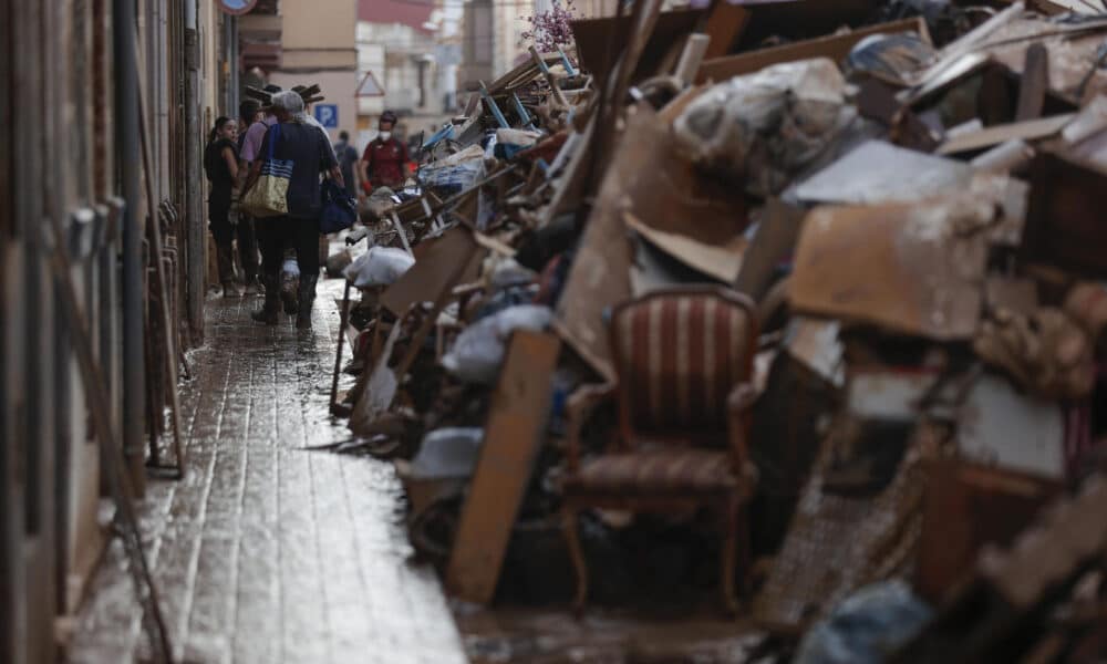 Voluntarios y vecinos trabajan para despejar una calle de Paiporta (Valencia), este martes. Una semana después del paso de la dana, varios de los pueblos más afectados siguen "en shock" y con grandes necesidades, más allá de comida o productos de limpieza y desescombro, a pesar de la ayuda de los miles de voluntarios y el aumento de efectivos de la UME, ejército, bomberos y policías. EFE/ Manuel Bruque