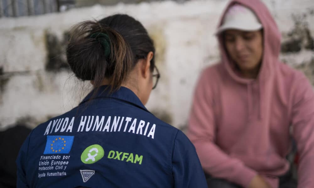 Fotografía cedida por Oxfam que muestra una funcionaria de esta organización mientras hablan con migrantes centroamericanos en Costa Rica. EFE/Oxfam